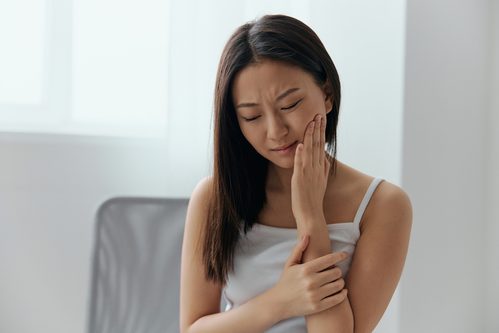 冷たいものがしみて歯を押さえる女性 高額商品が売れない理由を歯医者のたとえで